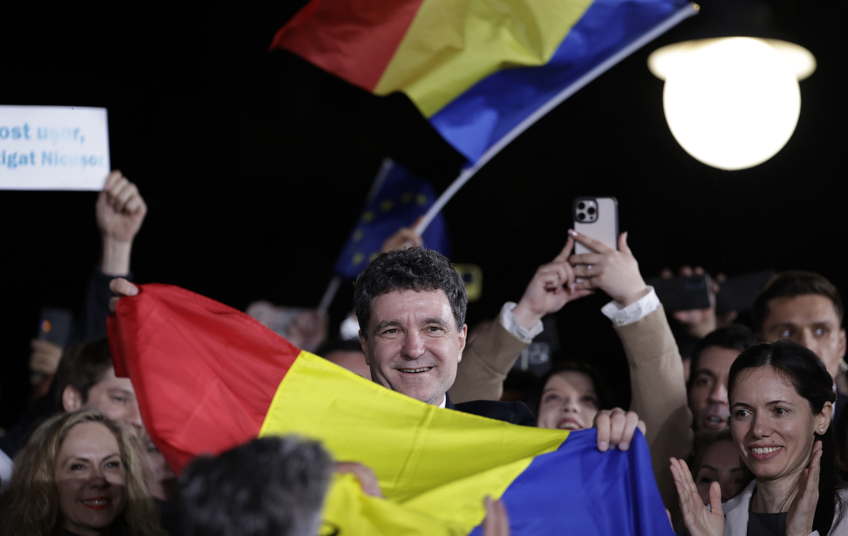 Onafhankelijke kandidaat Nicușor Dan wint Roemeense verkiezingen Nicusor Dan houdt om een menigte lachend een Roemeense vlag vast