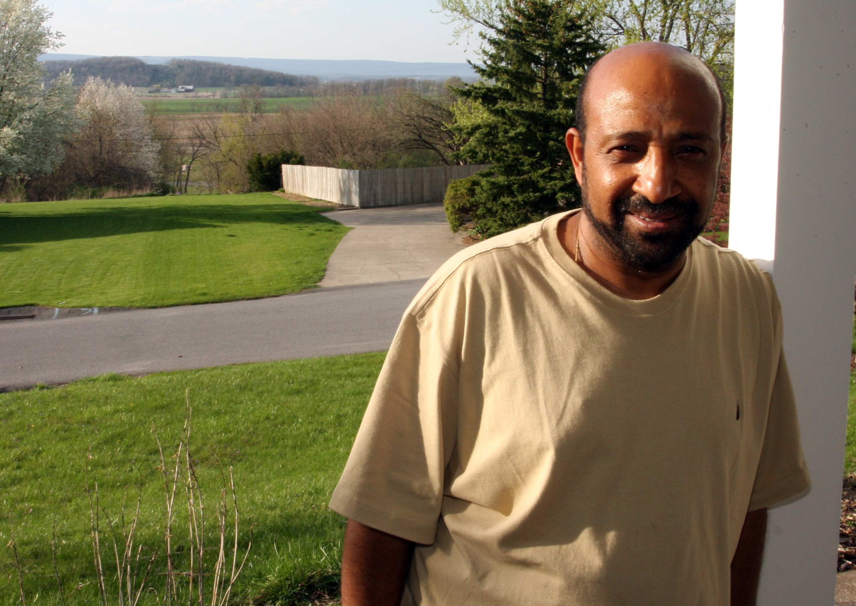 Dr. Berhanu Nega voor zijn woning in Lewisburg, in 2009. Het contrast tussen zijn nieuwe en oude leven kon nauwelijks groter zijn. – © AP Photo / John Zeedick