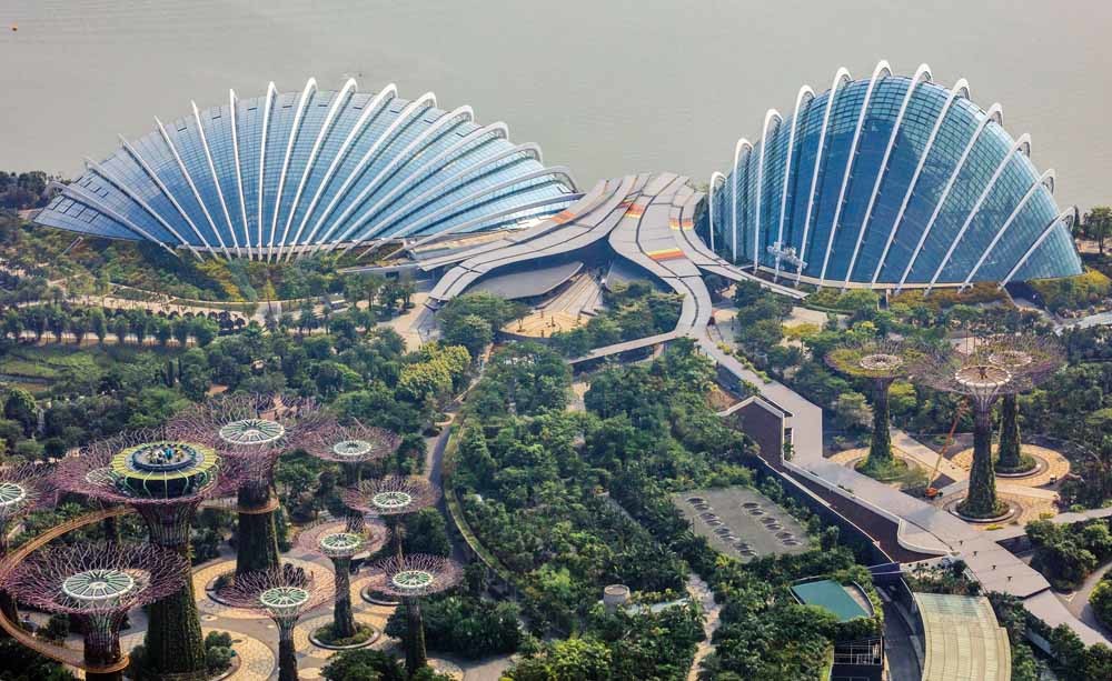 Gardens by the Bay in Singapore. Het park bestaat onder meer uit een futuristisch bos van metalen bomen (‘Supertree grove’) en twee grote kassen. – © Getty Images