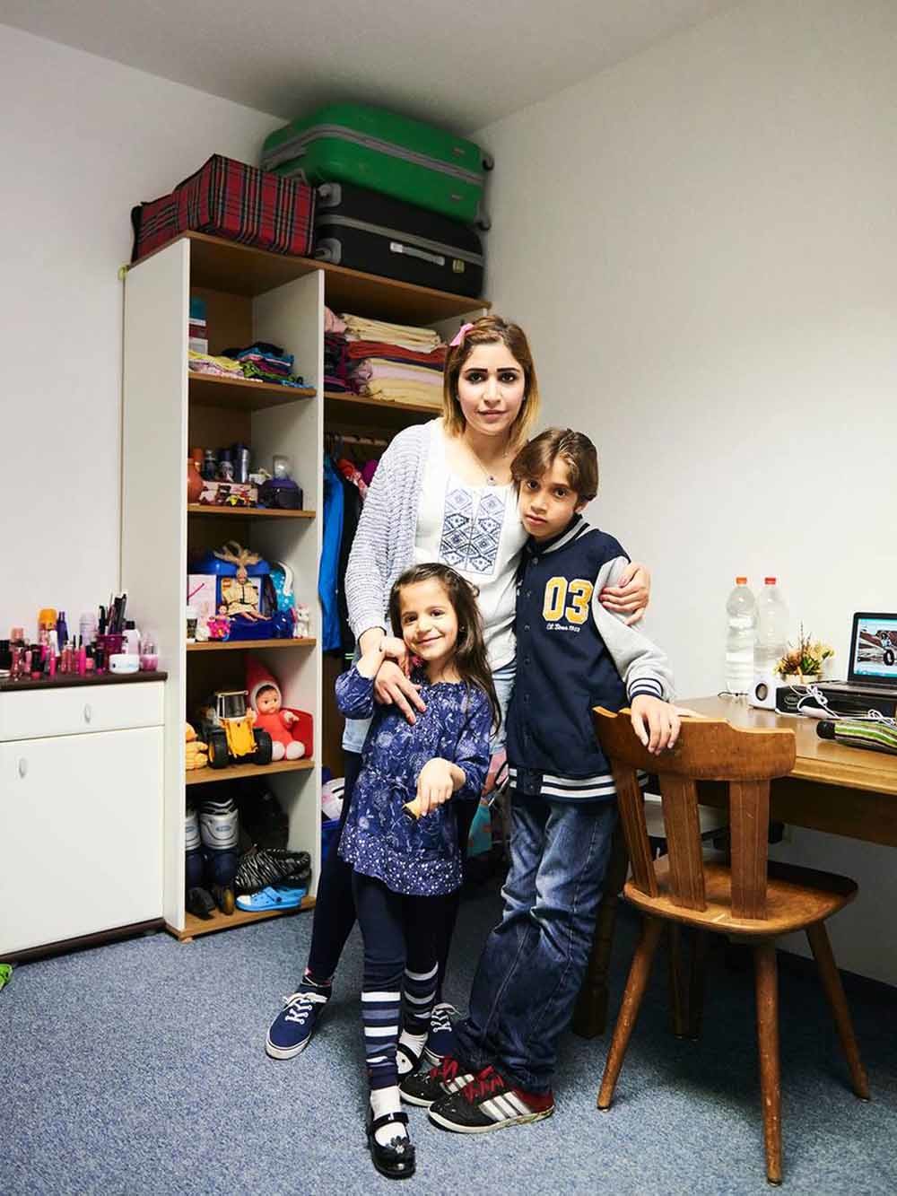 Nahed Asker met haar dochter Tala en haar zoon Said in hun woning in Wenen. Asker verloor haar man in de koelwagen. – © Philipp Horak