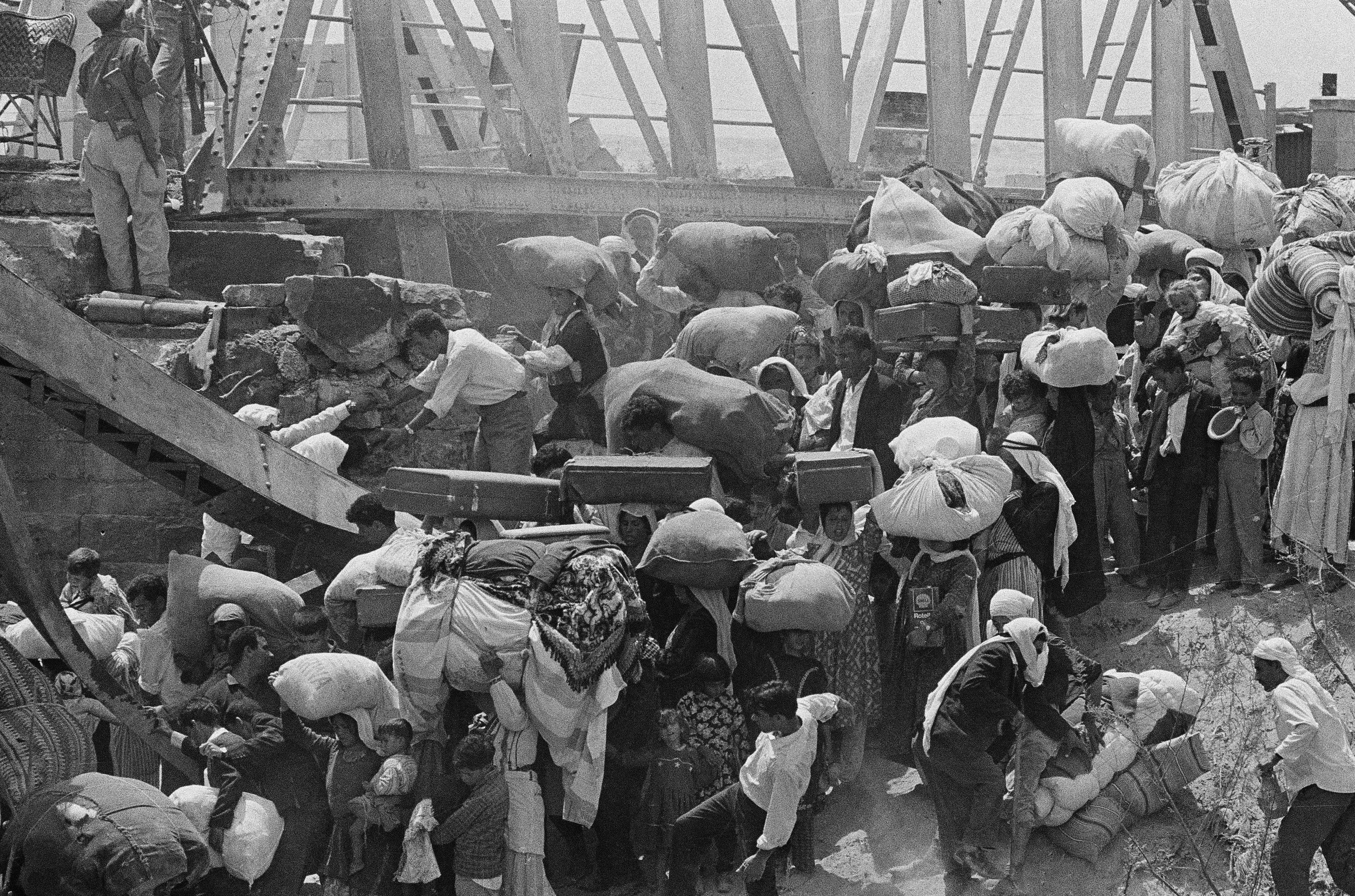 22 juni 1967. Palestijnse vluchtelingen maken zich klaar om via de verwoeste Allenbybrug de Jordaan over te vluchten uit het door Israël bezette gebied. – © AP Photo/Bernard FryZ