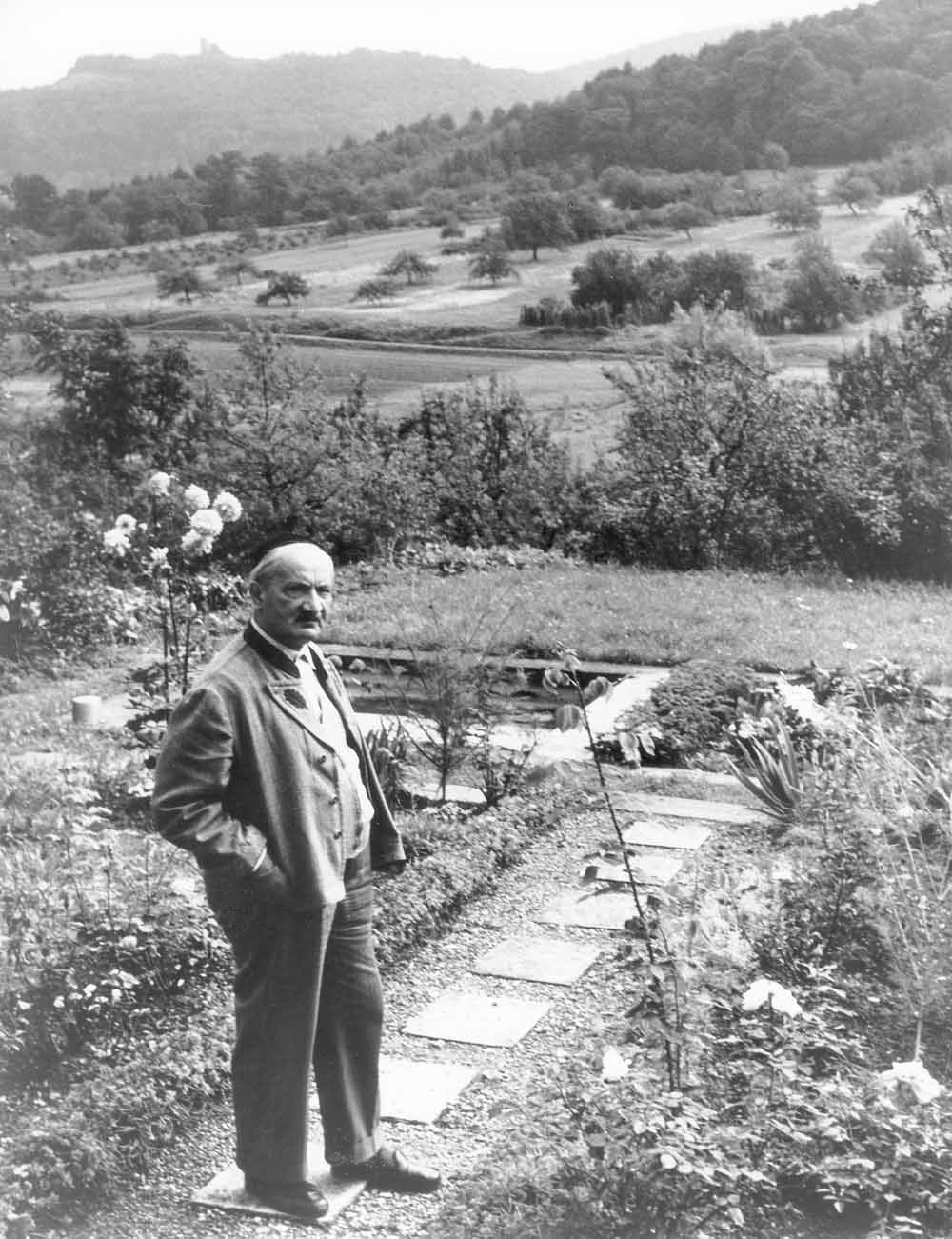 De Duitse filosoof en wandelaar Martin Heidegger in zijn tuin, rond 1964. – © Getty Images