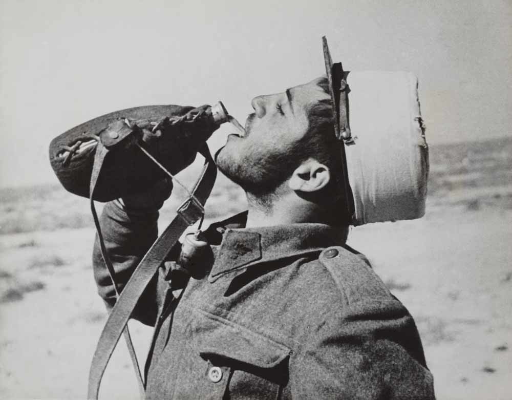 De legionair zoals we hem kennen, drinkend uit z'n veldfles middenin  de woestijn in 1942.   – © Everett Collection