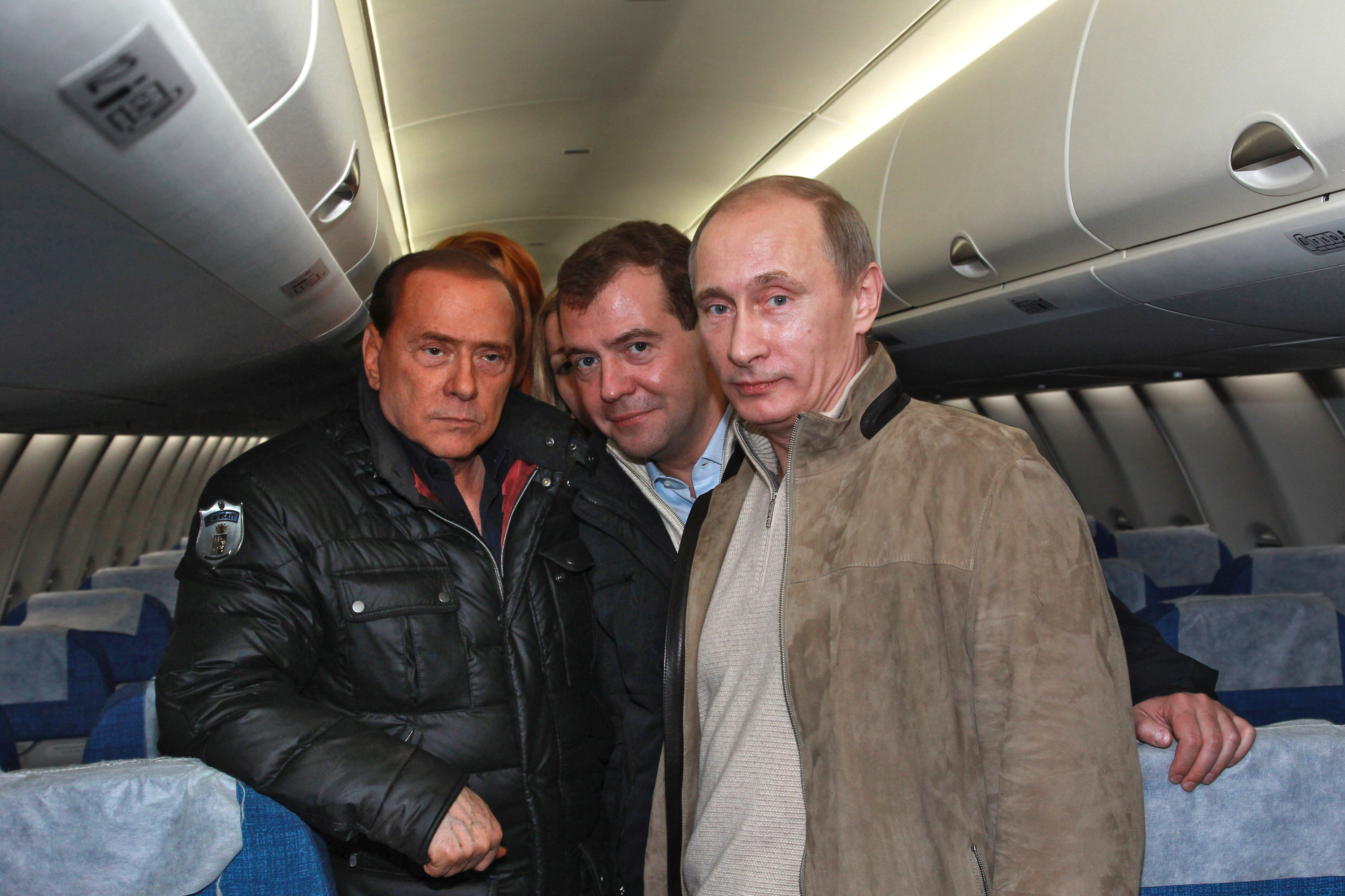 Poetin met de toenmalige Russische president Medvedev (midden) en Silvio Berlusconi (l) in een Super Jet 100 Sukhoi jetliner op het vliegveld in Sotsji in 2010. – © Reuters