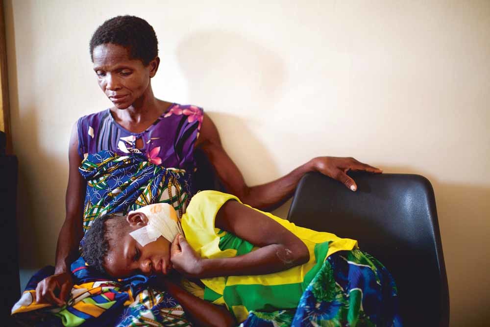 Kankerpatiënt Pilirani Shadi (12) met haar moeder in een ziekenhuis in Malawi. – © Kieran Dodds