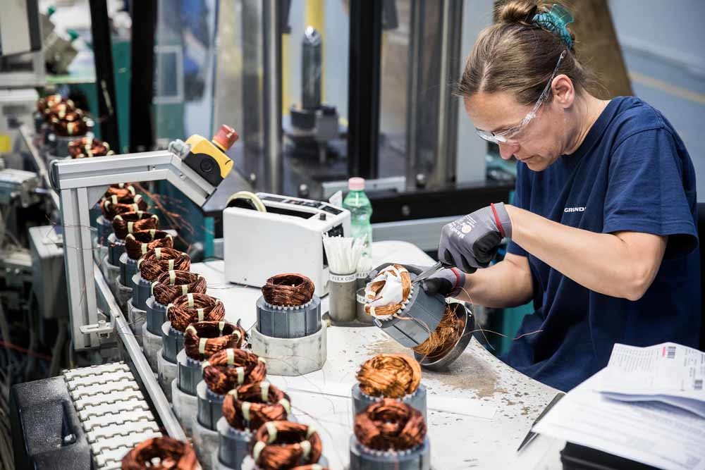 Een fabrieksmedewerkster aan de lopende band. – © Akos Stiller / Getty