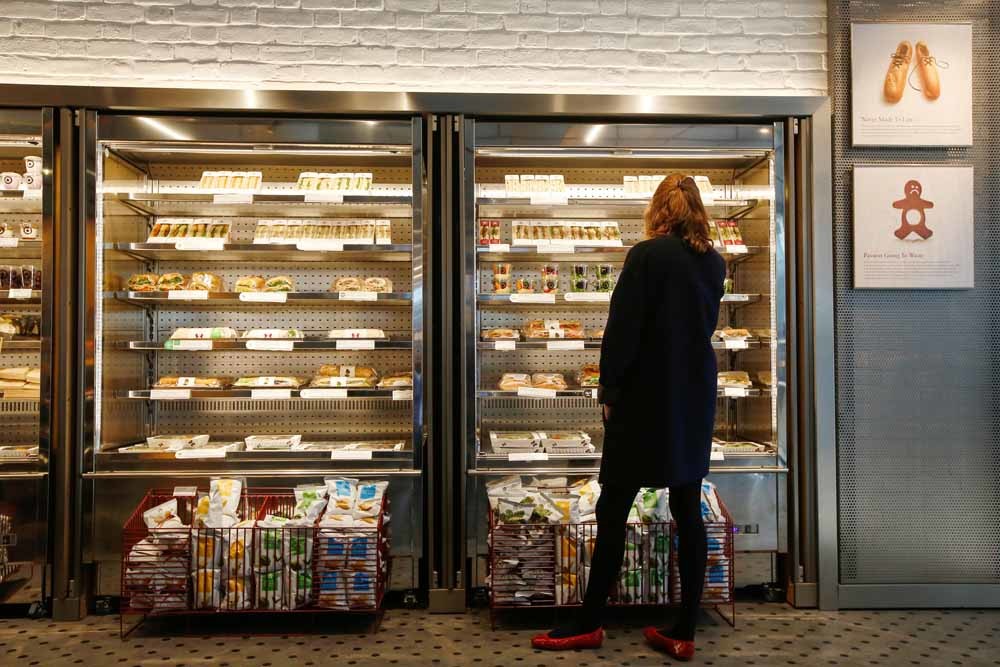 Een klant bekijkt het aanbod van Pret a Manger in een filiaal in Londen. – © Luke MacGregor / Getty