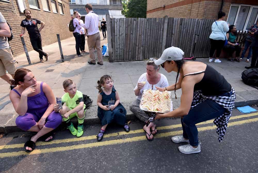 Buurtbewoners delen elkaar sandwiches uit.