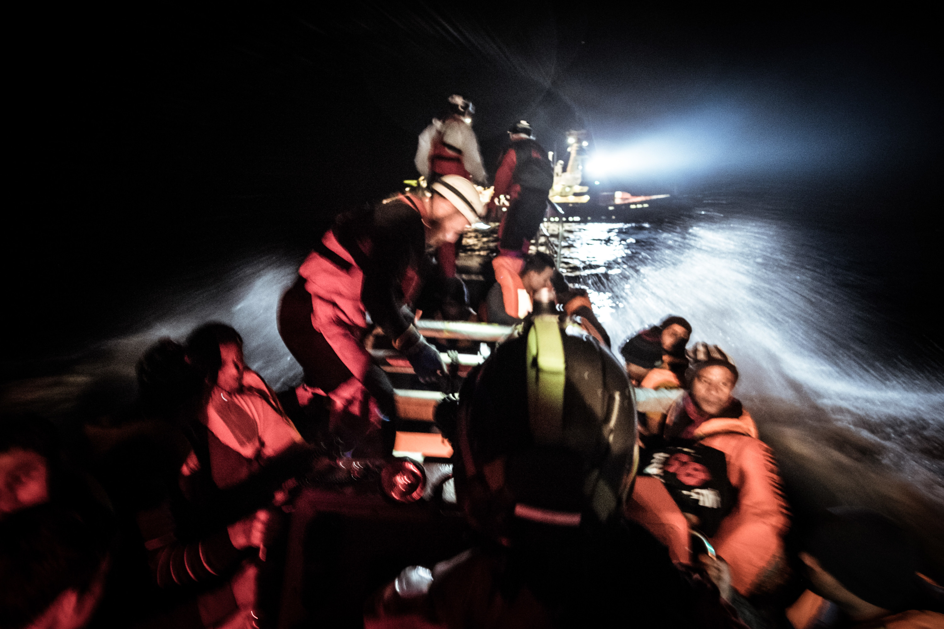 Migranten worden vlak bij de kust van Libië gered van een houten boot, 3 maart 2017. – Marco Panzetti / NurPhoto via Getty Images)