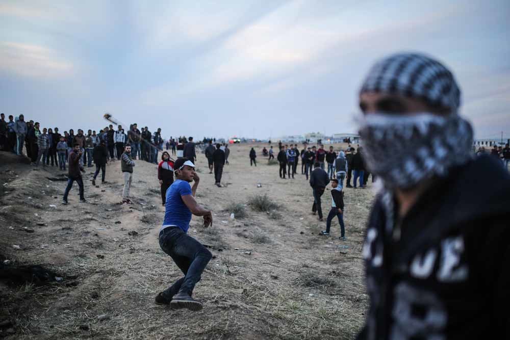 Een Palestijnse demonstrant gooit met stenen naar het Israëlische leger tijdens de mars van de terugkeer. – © Getty