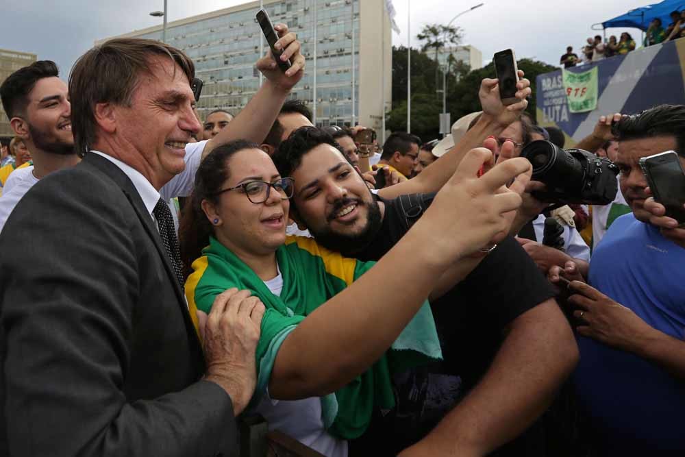 Tegenstanders van Lula maken een selfie met de extreemrechtse kandidaat Jair Bolsonaro. – © Eraldo Peres / HH