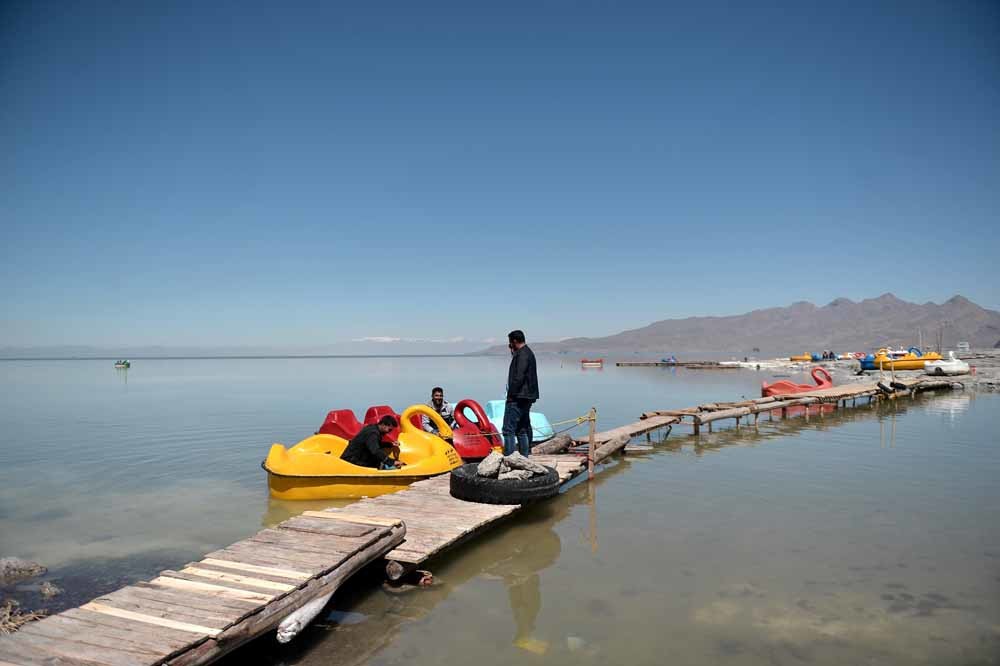 Toeristen op waterfietsen in het Oermiameer in Iran. Het grootste meer in het Midden-Oosten dreigt volledig op te drogen. – © Getty Images