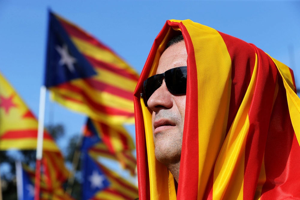 Een man gehuld in ‘estaladavlag’ tijdens een onafhankelijksbetoging op het Plaza Catalunya in Barcelona (oktober 2014). – © Joan Valls / Hollandse Hoogte