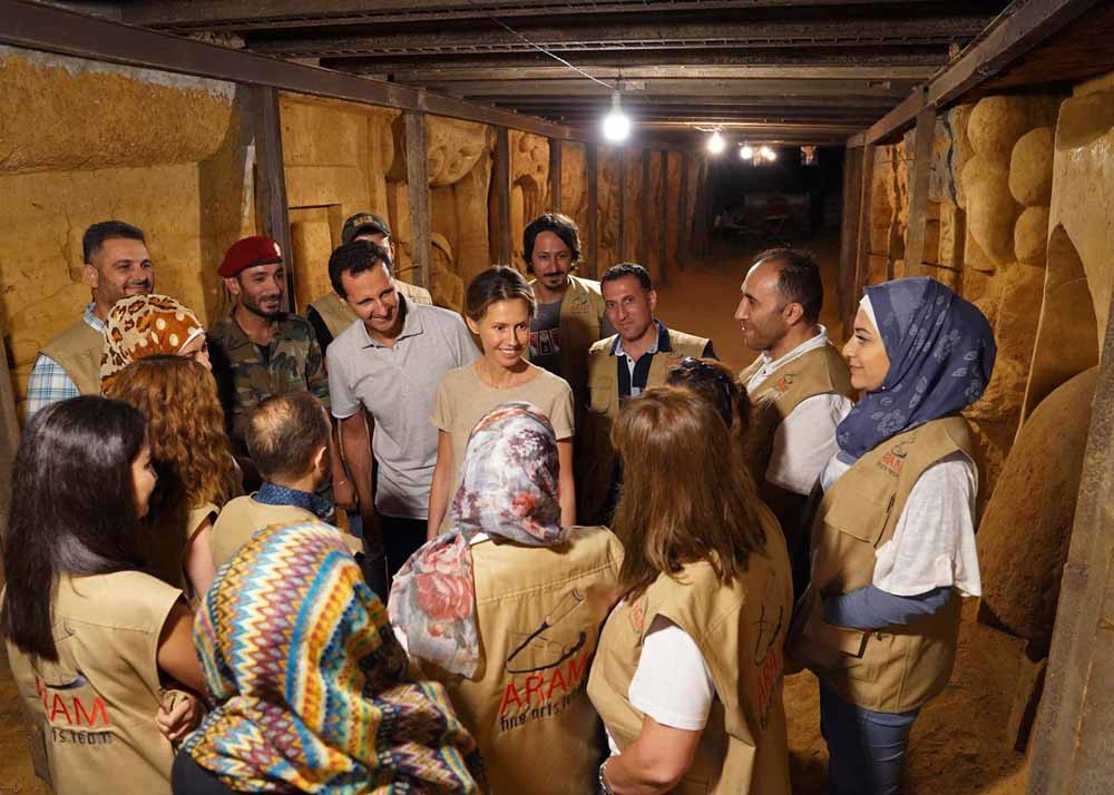 President Assad en zijn vrouw bekijken een ondergronds patriottisch kunstproject. – © HH