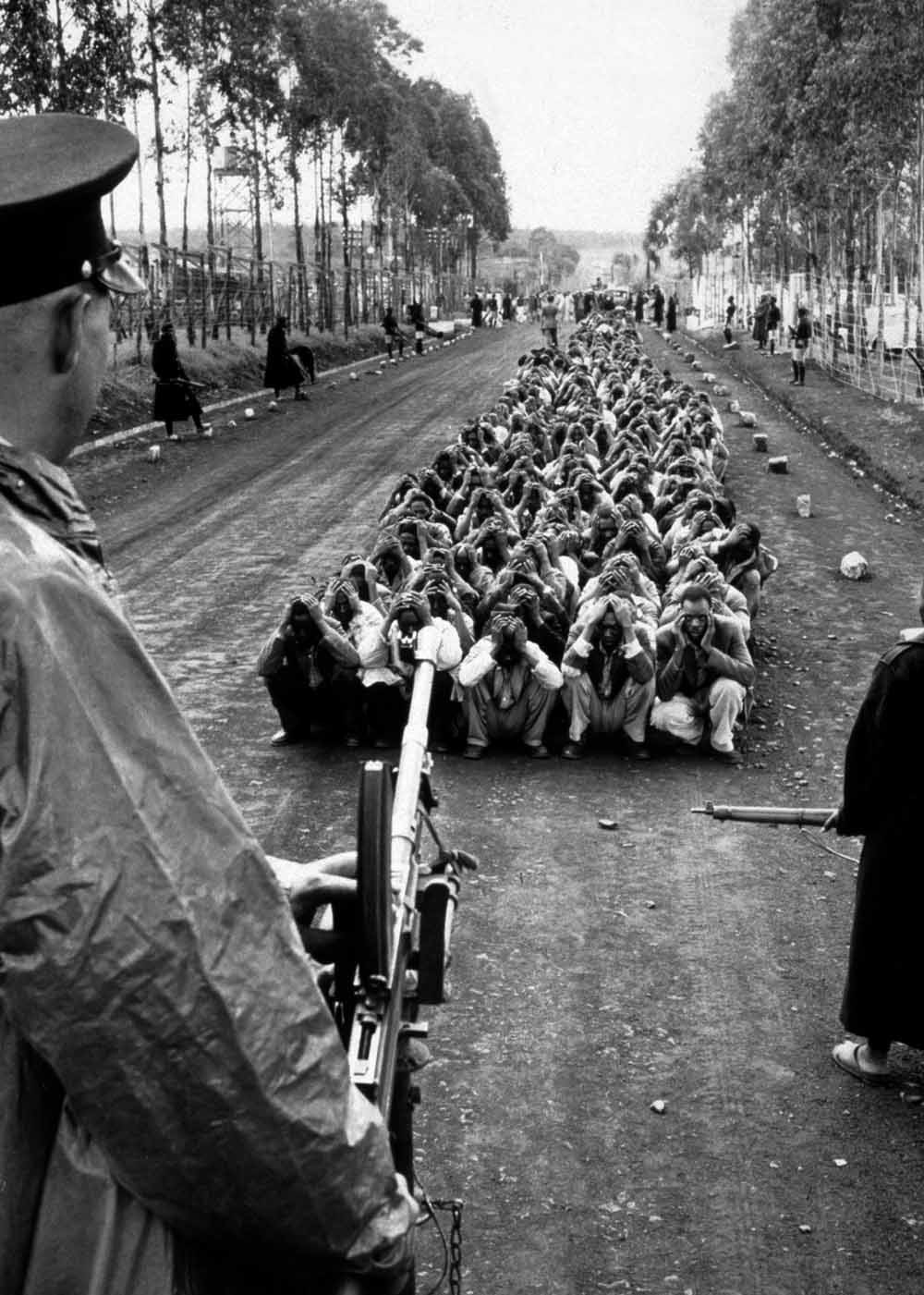 Britse militaire politiemannen bewaken vermoedelijke Mau Mau-rebellen en bewaken een wegcontrole tijdens de Mau Mau-opstand (1952-1960) tegen het Britse koloniale bewind in Kenia. – © Corbis via Getty Images; 2. De Britse militaire politie voert een we