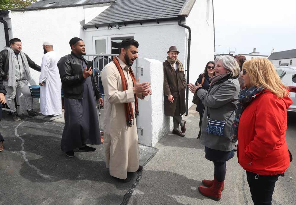 Aihtsham Rashid (midden) praat met buurtbewoners bij de opening van de moskee op het Isle of Lewis. – © Getty Images