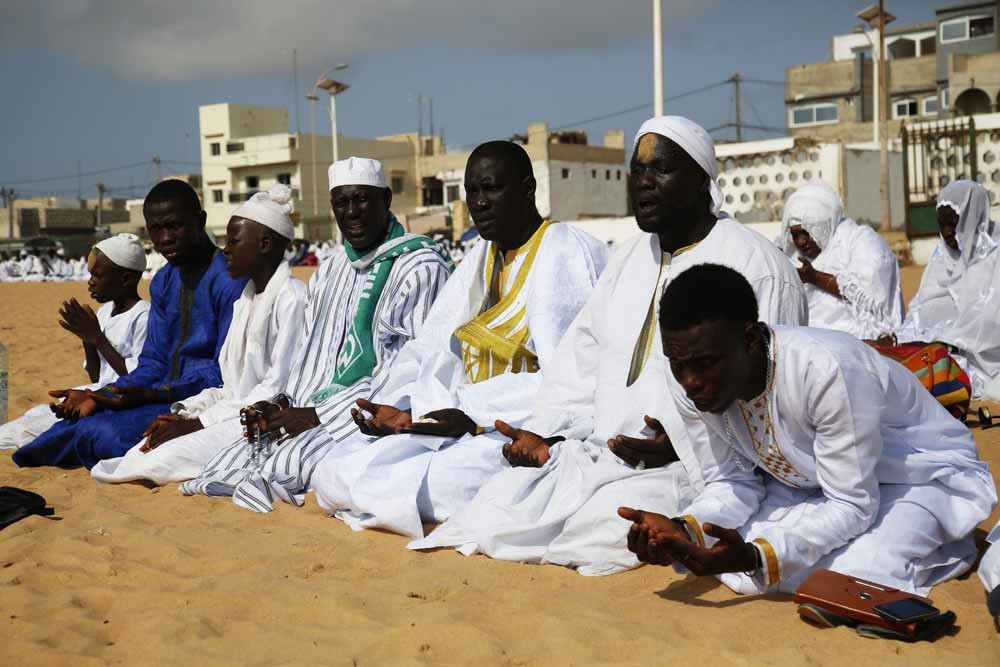 Senegalese moslims in gebed bij een moskee aan het strand van Dakar. – © Getty Images