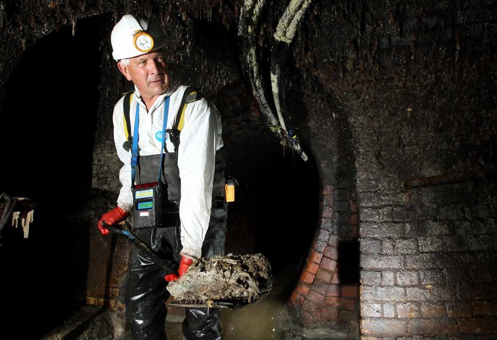 Een medewerker van Thames Water met een stukje vetberg. – © Dominic Lipinski / Getty Images