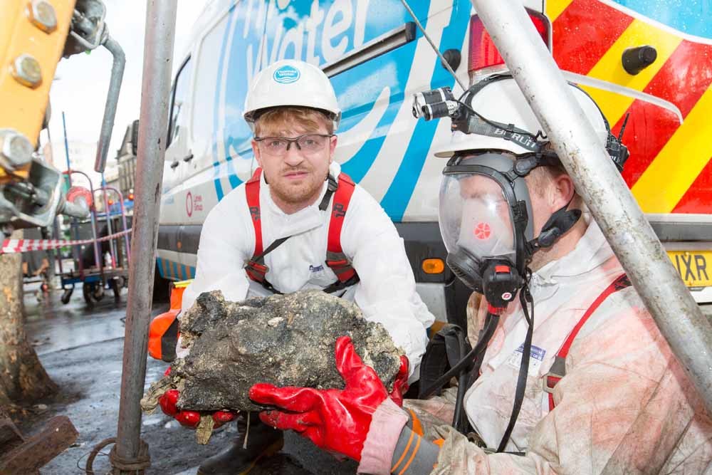 Journalist Sam Fishwick (r.) van de Evening Standard met een stukje van Fatty McFatberg, die even veel woog als elf dubbeldeksbussen. – © Matt Writtle / ES