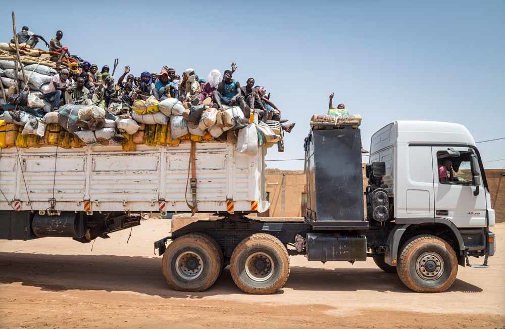 Migranten verlaten de stad Agadez op weg naar Dirkou, de laatste oase voor de grens met Libië. – © Getty
