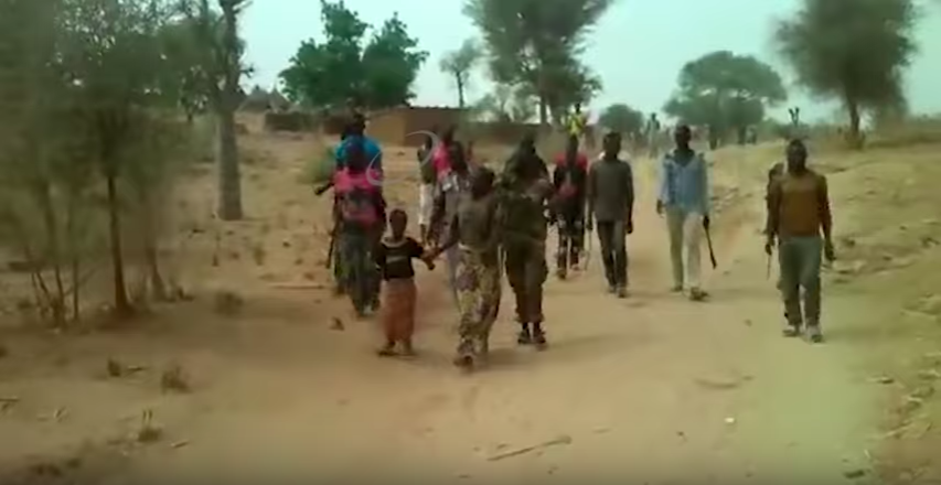 De vrouwen die ervan werden beschuldigd bij Boko Haram te horen worden samen met hun kinderen door een groep soldaten naar de dood geleid. Still uit het filmpje dat viral ging.