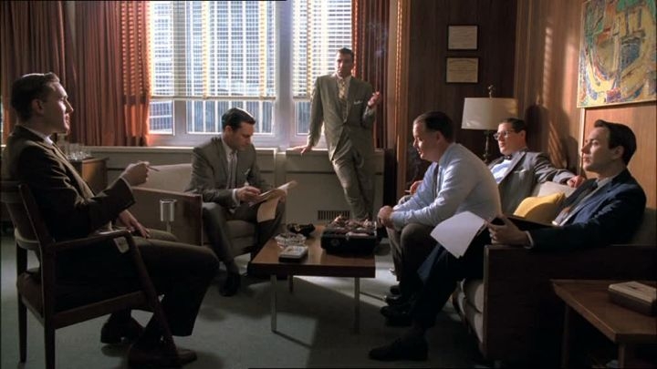 De mannen van reclamebureau Sterling Cooper in bespreking.