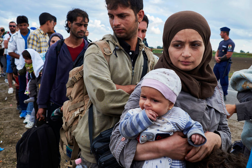 Begin september. Een groep migranten is er ondanks de grensversperring in geslaagd vanuit Servië Hongarije te bereiken, en rust zo goed en zo kwaad als het gaat uit in het grensdorp Roszke. – © Pierre Crom / Getty Images