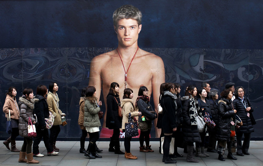 Een rij consumenten voor een reclamebord van Abercrombie & Fitch.  © Simon Dawson / Getty
