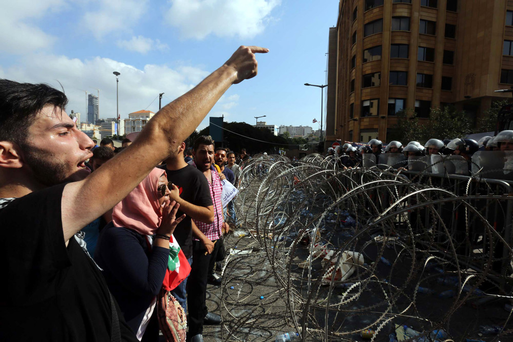Libanese demonstranten roepen slogans tegen de regering tijdens een recente protestbijeenkomst.  © Marwan Tahah / Corbis
