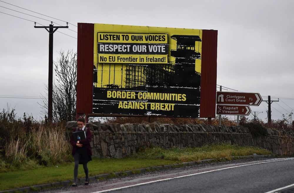 In Noord-Ierland loopt een student langs een anti-Brexit-billboard. De grens tussen de Republiek Ierland en Noord-Ierland is een heet hangijzer in de onderhandelingen. – © Getty Images