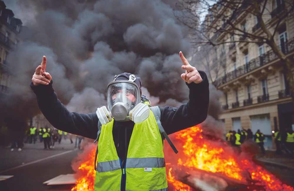 De gele hesjes zetten tijdens de demonstraties van 8 december in Parijs een barricade in brand vlak bij de Champs-Élysées. – © Getty Images