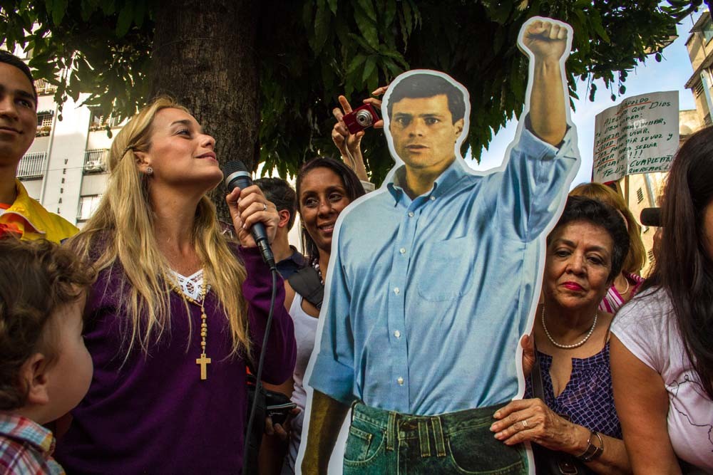Lilian Tintori (tweede van links), de echtgenote van Leopoldo López, met een afbeelding van haar gevangen gehouden man in 2014. © Manuel Hernandez / Xinhua