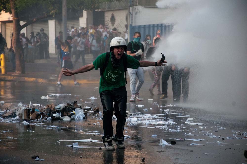 De politie zet een waterkanon in tijdens de protesten in 2014. – © Cristian Hernandez / Getty