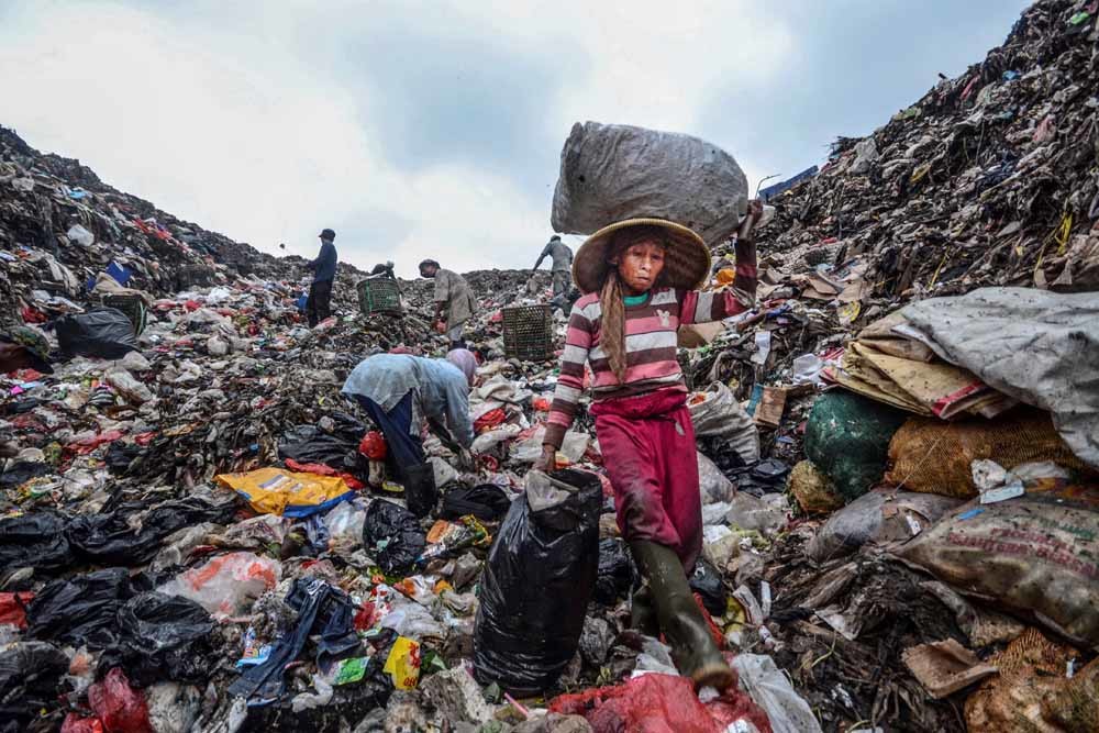 Afvalverzamelaars zoeken plastic om te recyclen op Bantar Gebang, de grootste vuilnisbelt van Indonesië. – © Getty Images