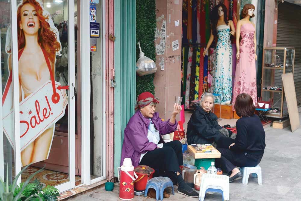 Drie vrouwen drinken thee in de straten van Hanoi. © UIG via Getty Images