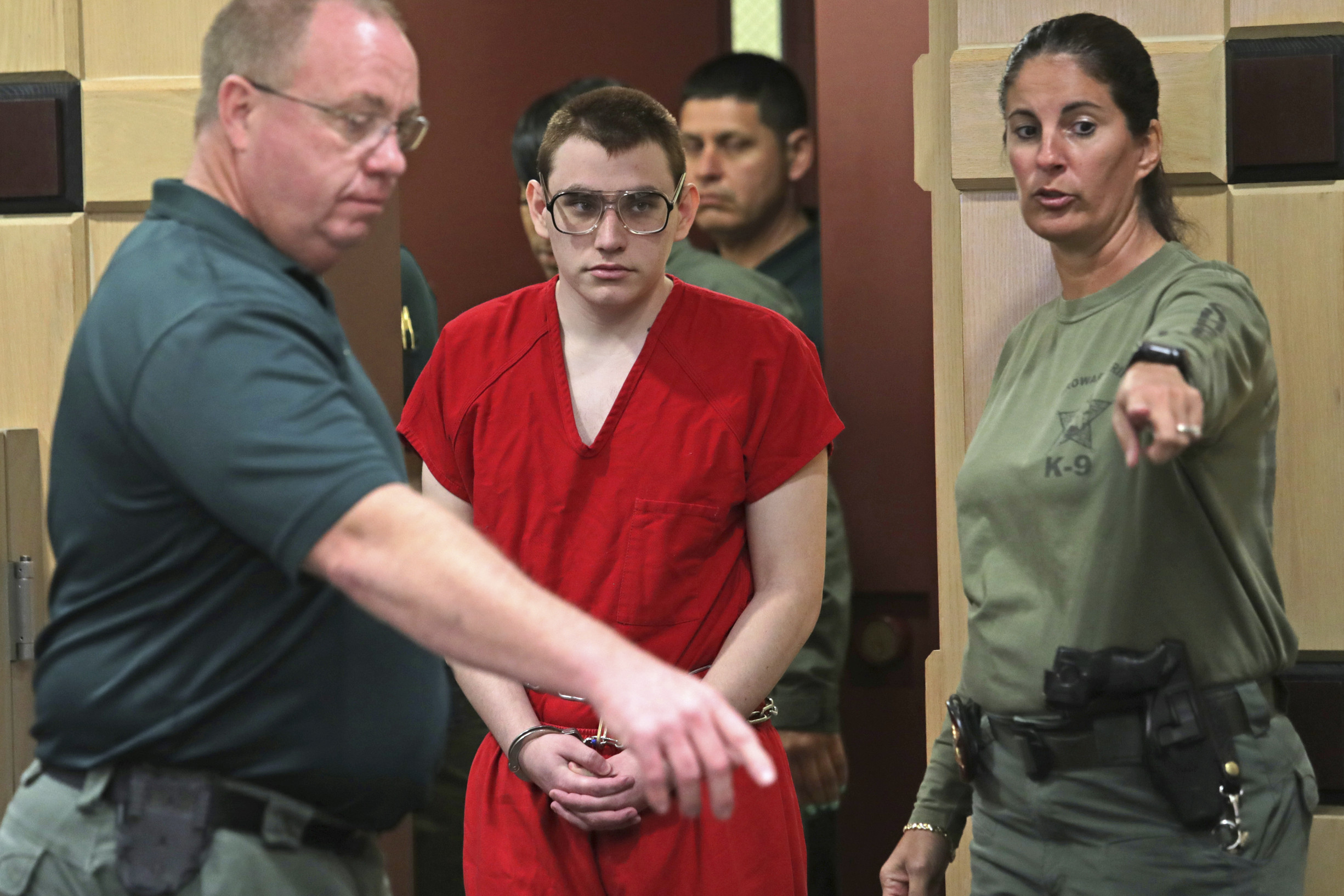 Nikolas Cruz wordt de rechtszaal in begeleid voor een zitting over de vraag of hij onder toezicht moet blijven staan van een officier die hem naar zijn zeggen mishandeld heeft. – John McCall / South Florida Sun-Sentinel via AP / HH