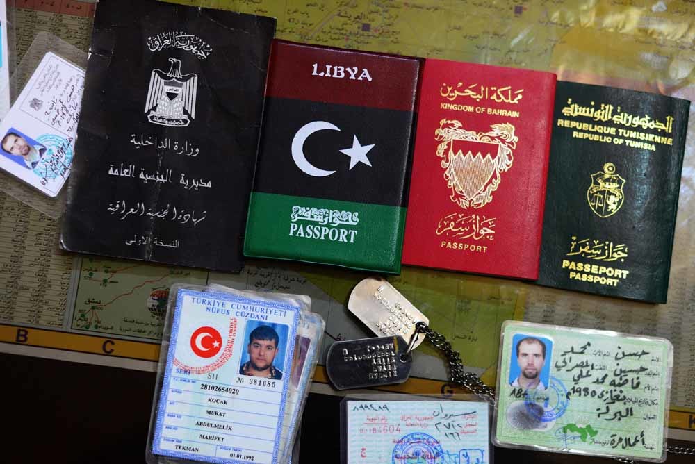 De identiteitsbewijzen van buitenlandse IS-strijders uit Irak, Libië, Bahrein, Tunesië en Turkije die via Turkije naar Syrië zijn gereisd. – © HH