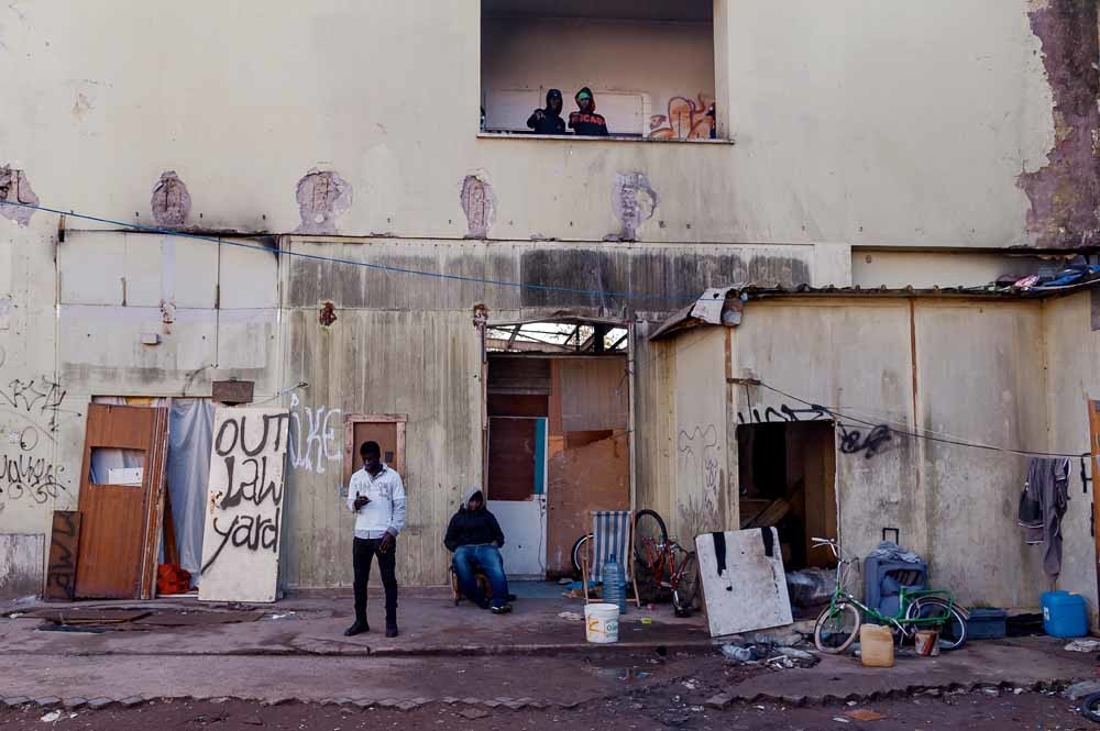 Migranten in een verlaten fabriek in Rome. – © Getty Images