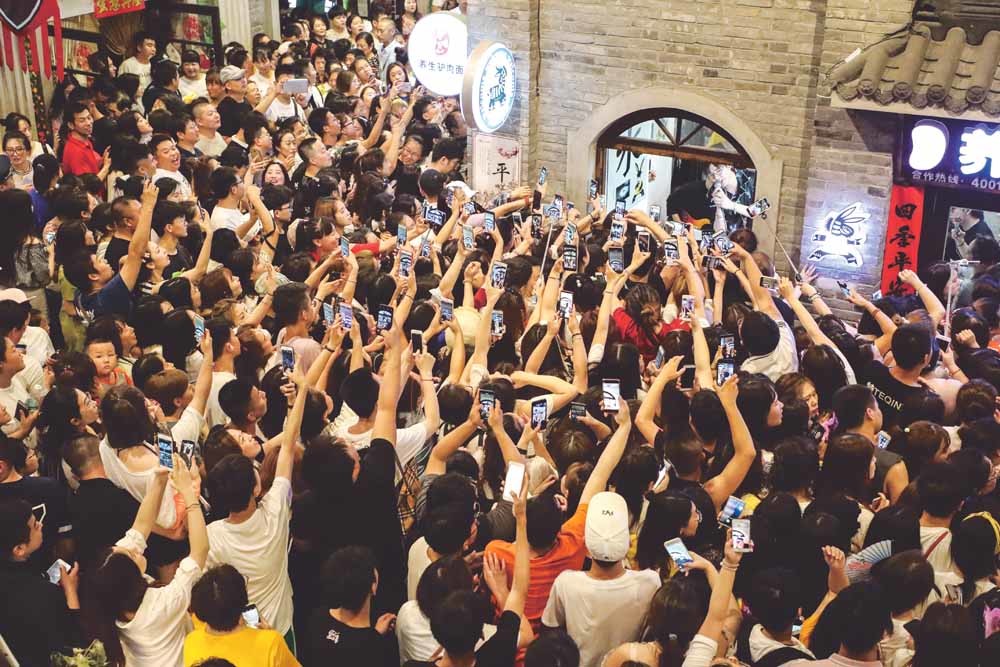 Fans maken filmpjes bij een optreden van Modern Brothers in Dandong (China). De jongensband heeft meer dan 20 miljoen fans op TikTok. – © Getty