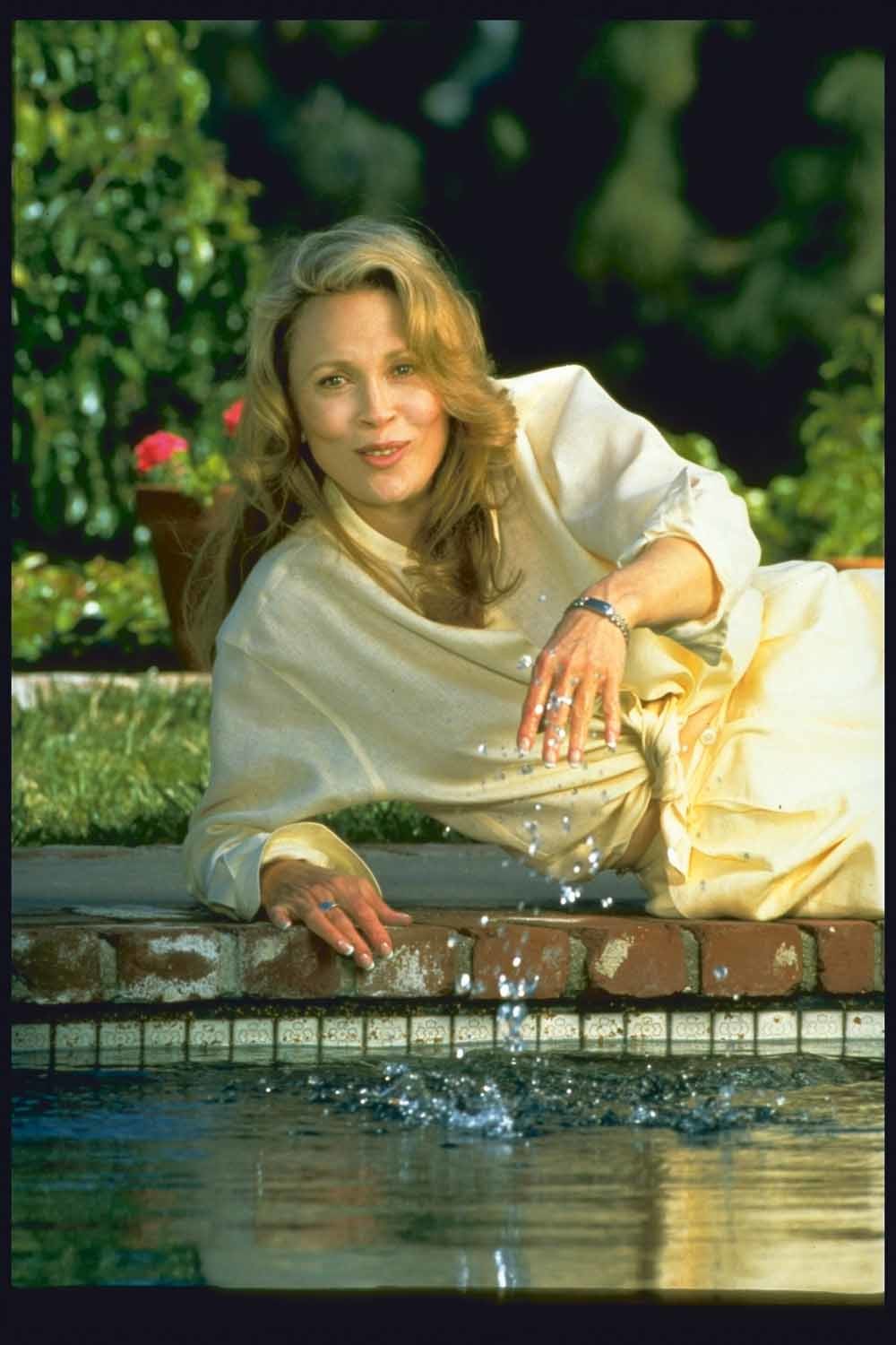 Actrice Faye Dunaway liggend aan de rand van het zwembad bij haar huis in West-Hollywood. © John Story / Getty Images