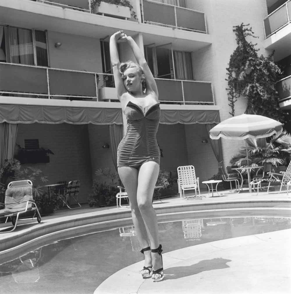 De Amerikaanse actrice Marilyn Monroe (1926-1962) staat naast een zwembad  in een strapless-badpak en hoge hakken, circa 1951.  © Archive Photos / Getty