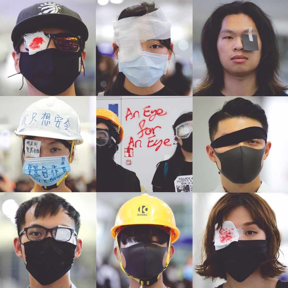Demonstranten in Hongkong dragen ooglapjes uit solidariteit met een mededemonstrant die zijn oog is verloren door een rubberkogel.  © Kin Cheung / AP Photo