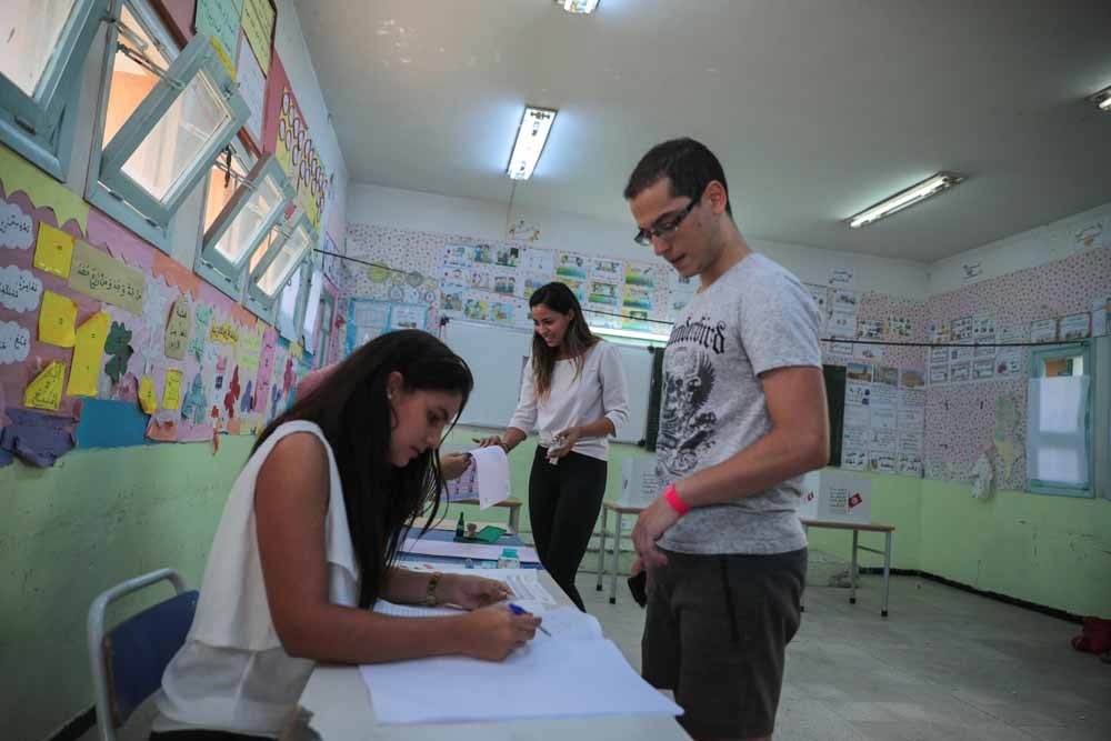 Jonge Tunisiërs in een stemlokaal in Tunis tijdens de eerste ronde van de presidentsverkiezinging in Tunesië. – © Mosa’ab Elshamy / AP Photo