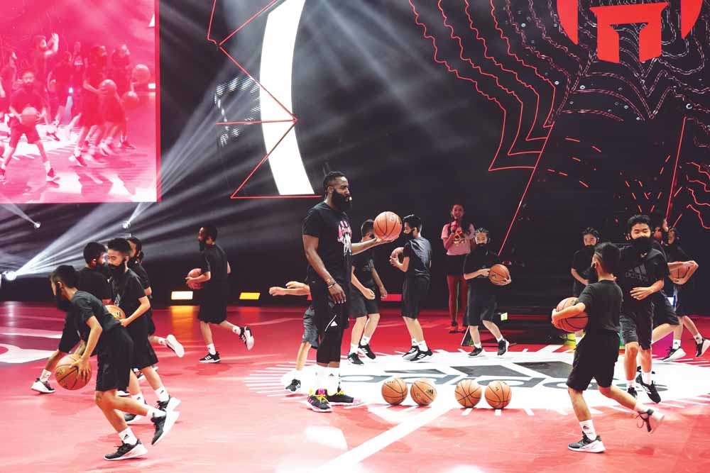 James Harden geeft een clinic aan jonge fans met opgeplakte baarden – het handelsmerk van Harden –  in het Tainhe Sports Centre in Guangzhou op 23 juni tijdens  zijn door Adidas gesponsorde tournee door China. © Visual China Group / Getty