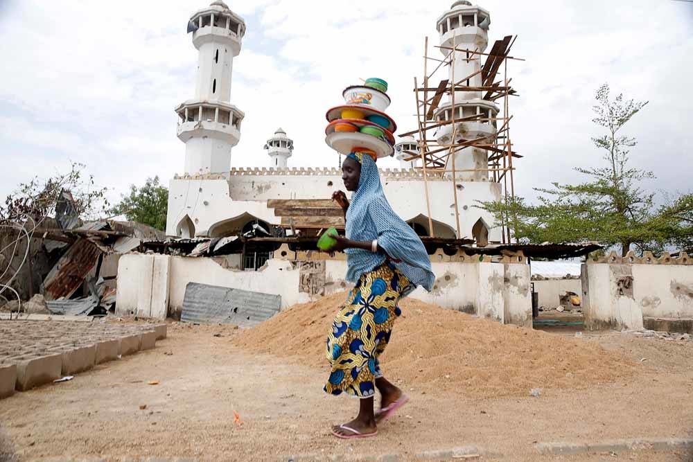 Een meisje wandelt langs een vernielde moskee in de Nigeriaanse stad Mararaba, die door het leger is terugveroverd op Boko Haram in 2015. – © Akintunde Akinleye / Reuters 