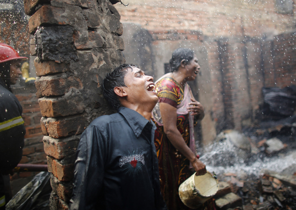 Wanhoop na een grote brand in de sloppenwijk Mirpur, in Dhaka, Bangladesh. De brand werd veroorzaakt door een kortsluiting. Tweehonderd huisjes en twintig winkels werden totaal verwoest. – © Andrew Biraj / Reuters