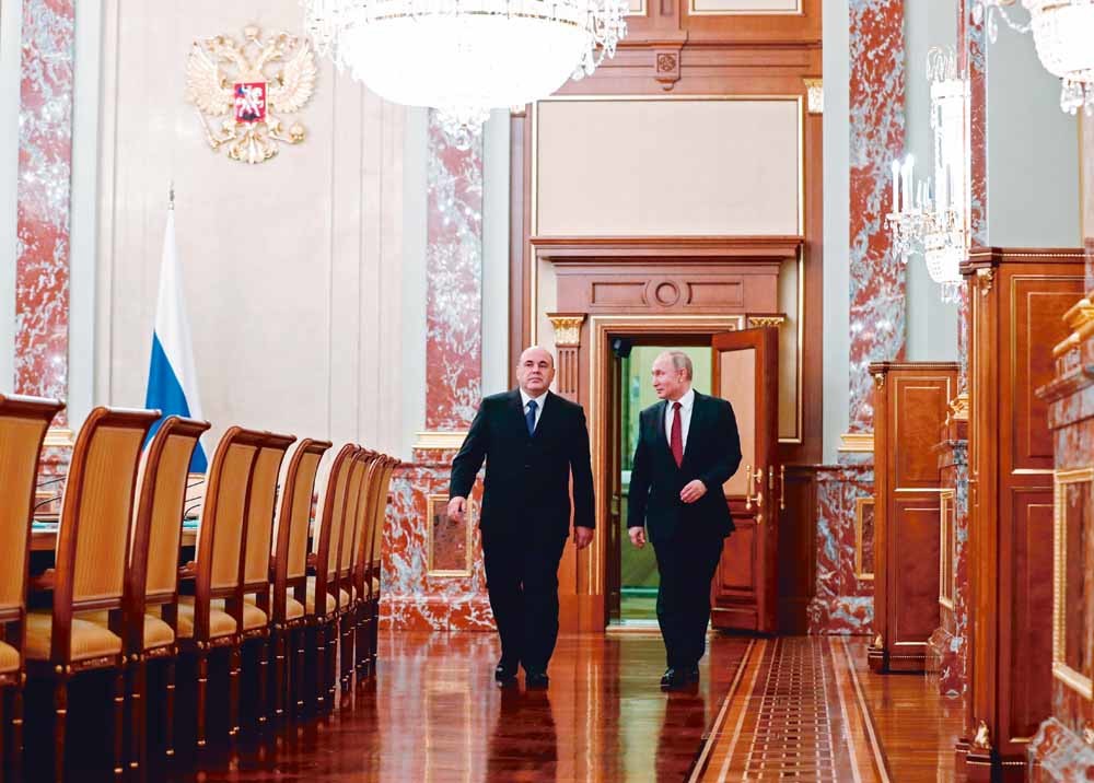 President Vladimir Poetin, rechts, en de nieuwe minister-president Michaïl Misjoestin lopen gezamenlijk naar het eerste overleg van het nieuwe kabinet, dat op 21 januari 2020 werd geïnstalleerd. © Dmitry Astakhov / HH