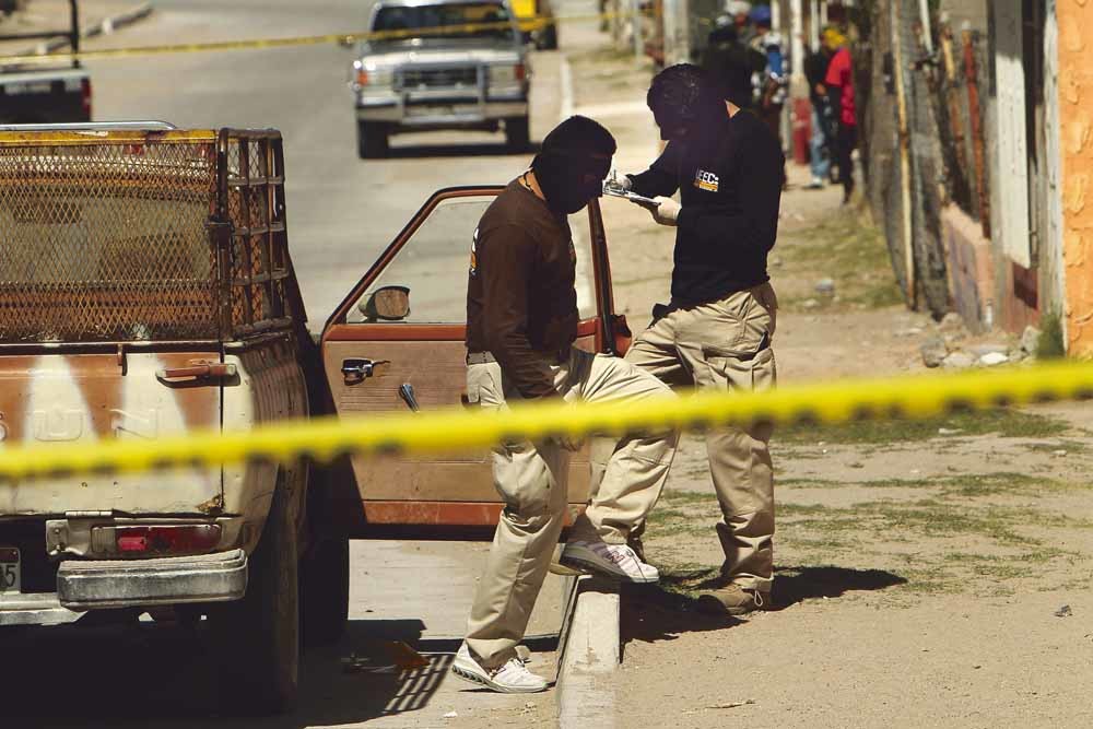 Een politieteam onderzoekt het plaats delict. Ondanks de inzet van militairen werden er in Ciudad Juárez nog nooit zo veel moorden gepleegd als in 2010. Er werden 3111 mensen vermoord op een bevolking van 1,4 miljoen. © Spencer Platt / Getty