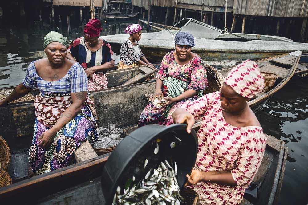 Vissersvrouwen onderhandelen met inkopers in Makoko, een gemeenschap aan de Lagos Lagoon die dreigt te worden ontruimd. © Jesco Denzel / HH