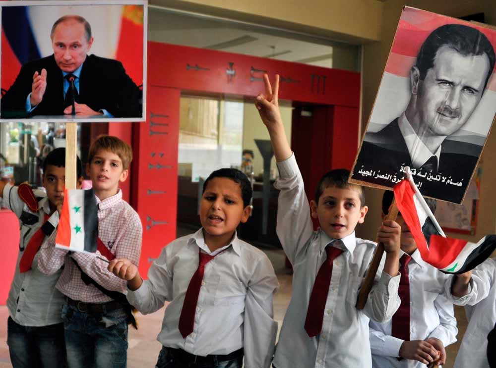 Kinderen in Latakia tonen foto’s van de Syrische president Assad en de Russische president Poetin om hun steun te betuigen aan het Russische ingrijpen. © Dmitriy Vinogradov / HH